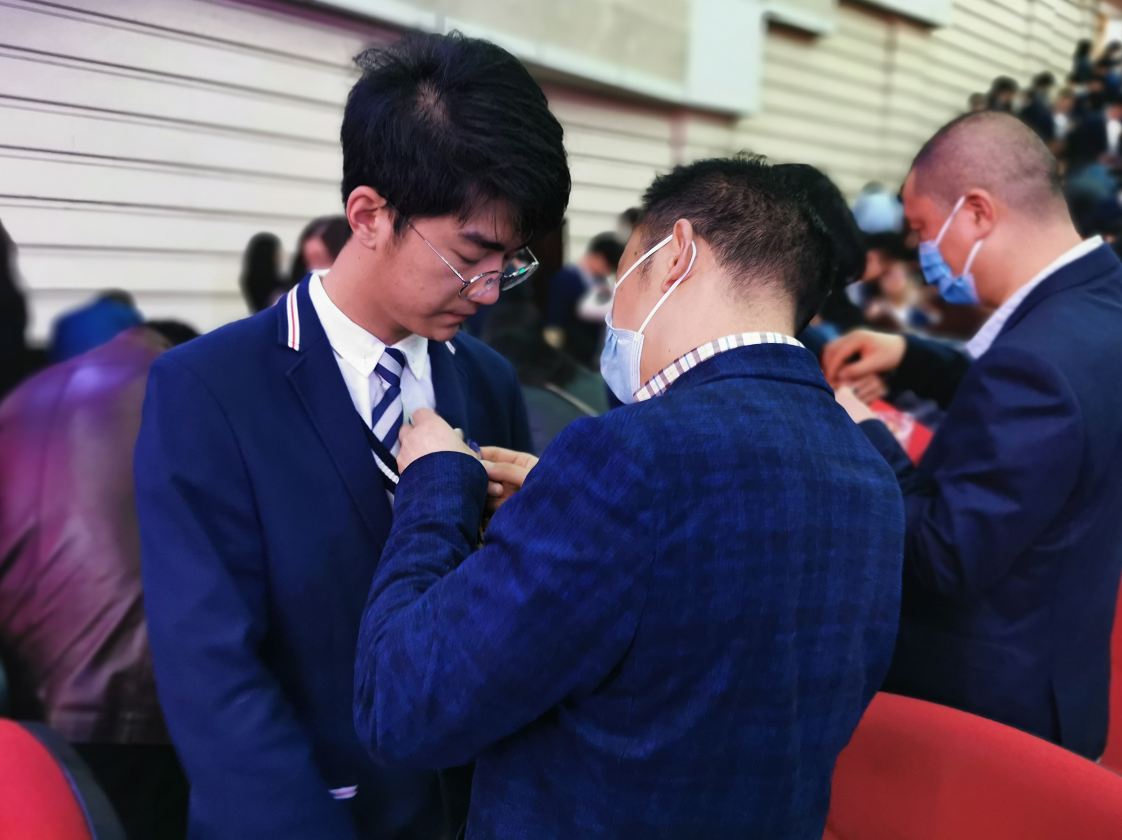 学生家长为孩子佩戴纪念徽章(央广网发)