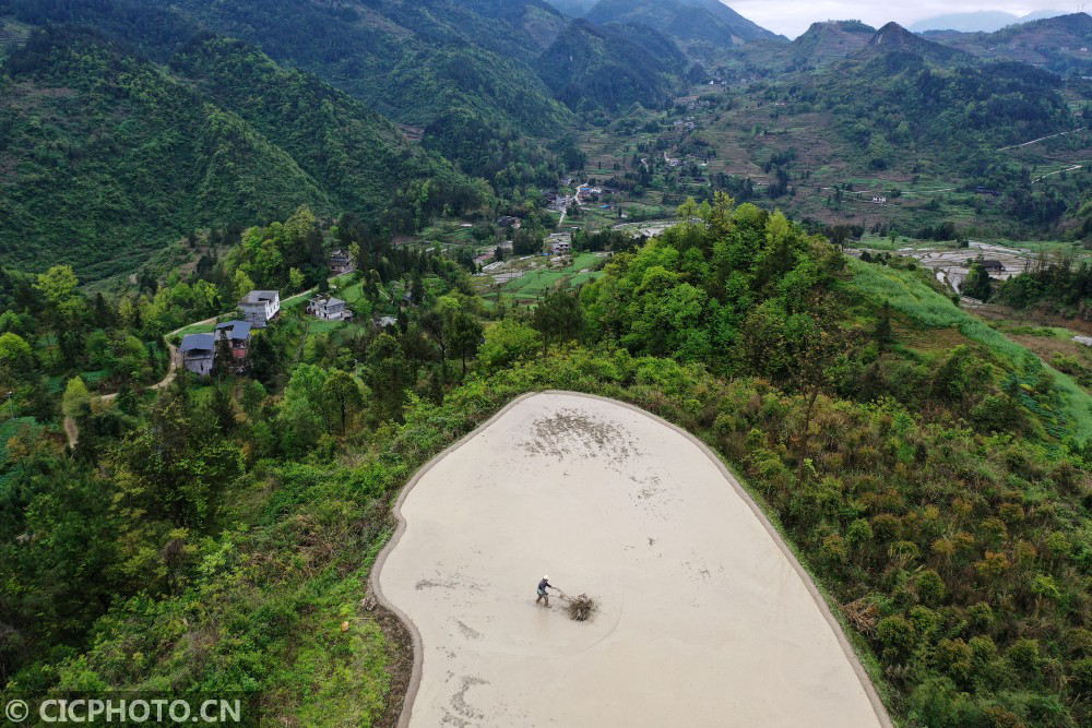 2021年4月22日,重庆市南川区石溪镇盐井村村民在梯田里劳作.