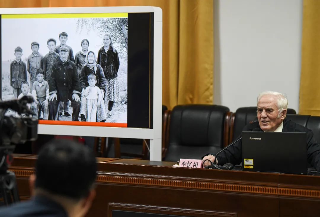 李忆祖老人在屏幕上放出40年前拍摄的照片,这是一户曾给予他帮助的