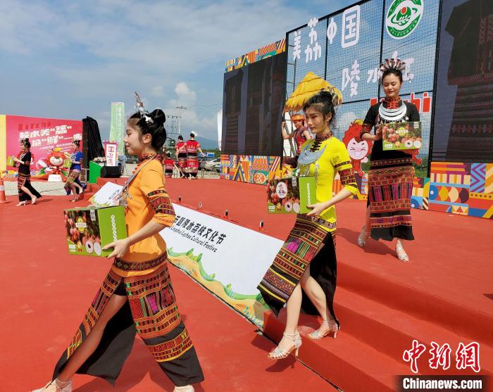 活动现场模特展示带有“陵水荔枝”区域公用品牌的礼盒装荔枝。记者王晓斌 摄