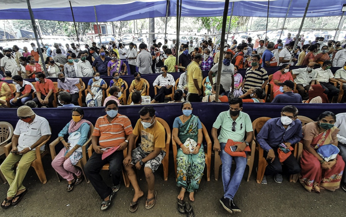 这是4月26日，众多市民戴着口罩在印度孟买排队等待接种新冠疫苗。新华社图