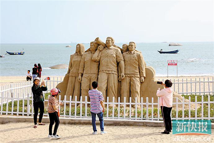 汕尾市陆丰市金厢镇的十二岗沙雕公园里,游客兴致勃勃地拍照.