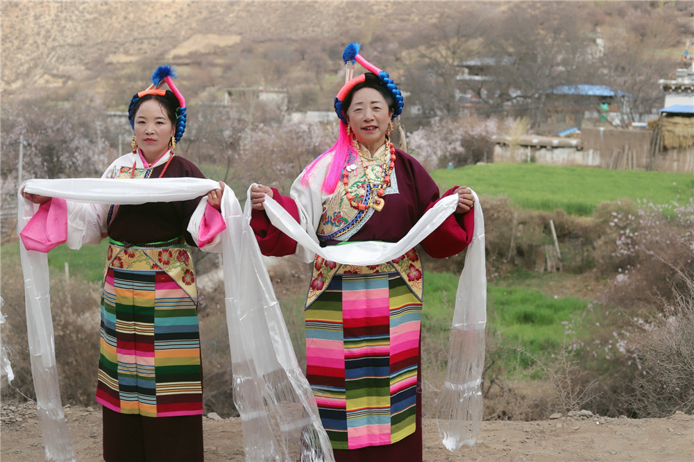 当地村民为远道而来的贵宾献上洁白的哈达.