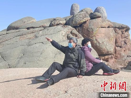 游客在草原石城奇石前拍照留念。古丽娜 摄