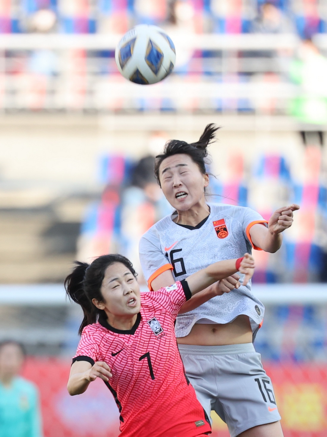 中国女足队员王晓雪(16号)与韩国女足队员李玟娥(7号)在场上拼抢