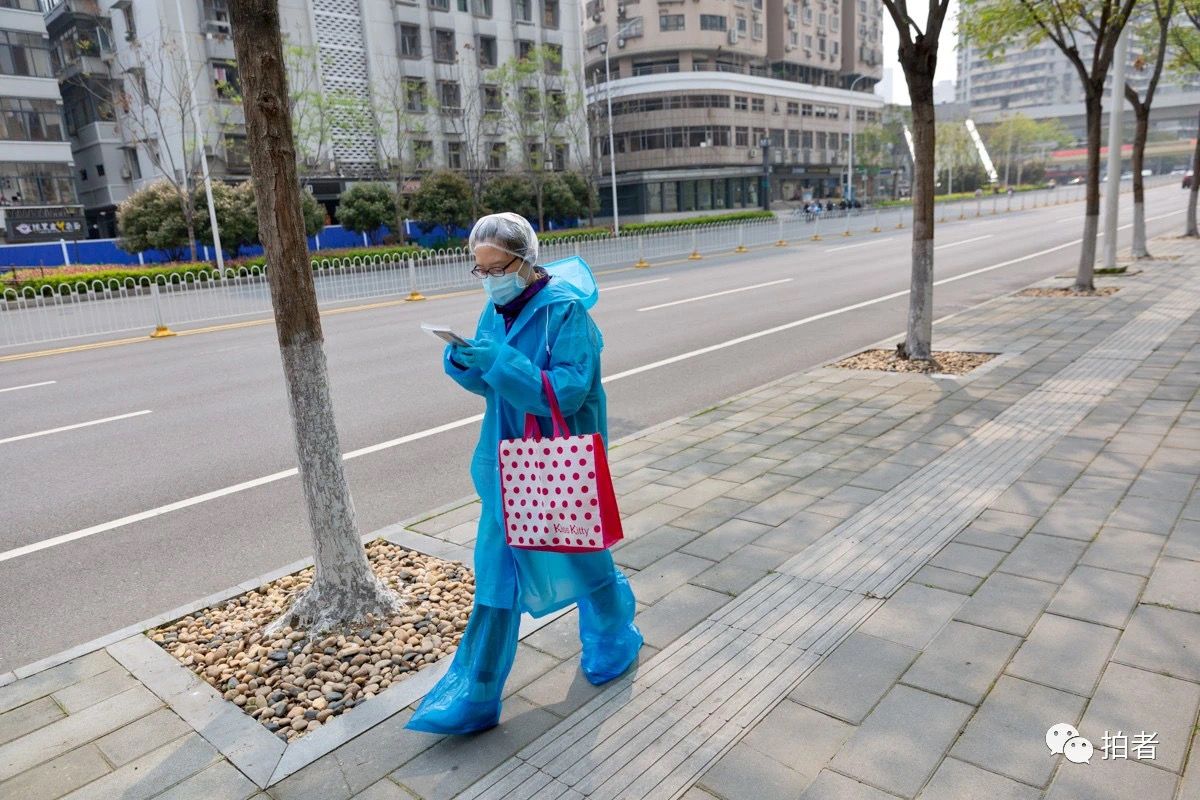 △ 2020年4月3日，路上没有车，一名路人穿着雨衣防范疫情。