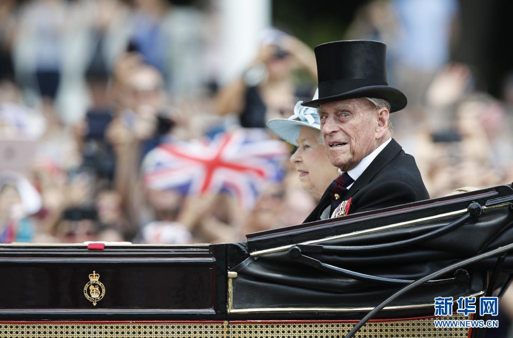这张2017年6月17日拍摄的资料照片显示，在英国伦敦，英国女王伊丽莎白二世和丈夫菲利普亲王乘坐马车离开白金汉宫，准备观看阅兵式，庆祝女王91岁官方生日。新华社记者韩岩摄