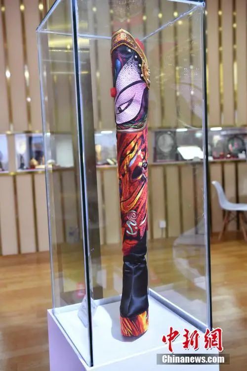 图为四川馆展示的川剧脸谱主题长靴。中新社记者 崔楠 摄