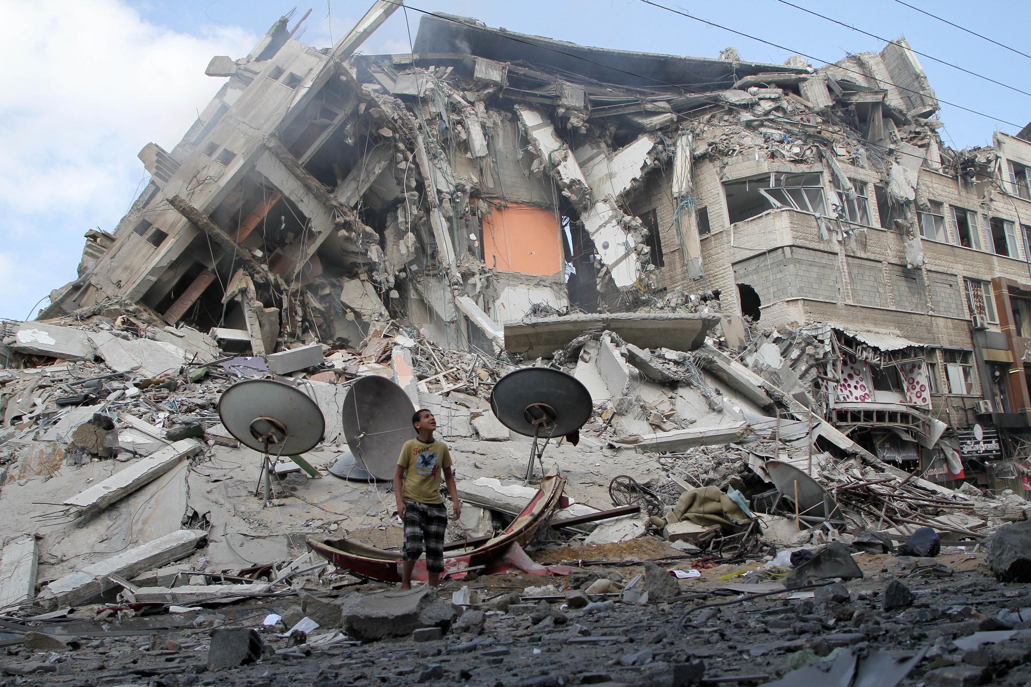 当地时间5月13日，一名巴勒斯坦男孩查看以军空袭造成的破坏情况。新华社 图