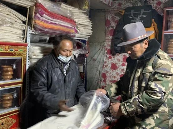 ▲普兰“国际商城”的尼泊尔商贩（右）在向顾客展示商品。（陈向阳/摄）