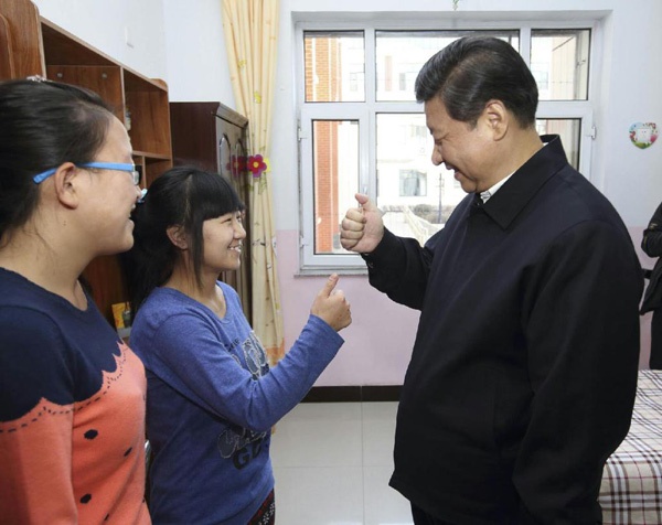 2014年1月28日，习近平在呼和浩特市儿童福利院宿舍向聋哑女孩王雅妮（左二）和放假“回家”的大学生闫志净学习哑语“谢谢”。新华社记者 兰红光 摄