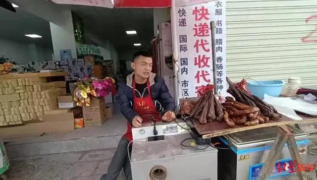 猪肉摊店主在销售自己熏制的腊肉、香肠等。