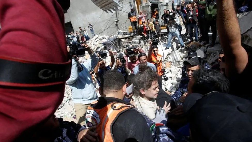 救援人员从加沙地带一座建筑物的废墟中救出一名6岁儿童（图源：外媒）