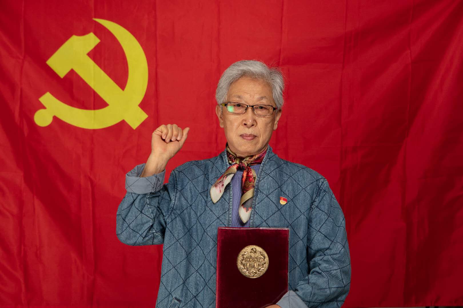 这个社区请党龄50年及以上的老党员与党旗合影