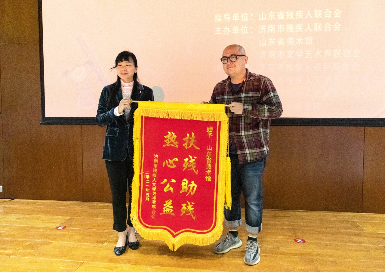 济南市残联向山东美术馆公共教育部副主任孙靖东赠送助残锦旗