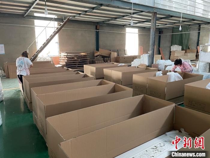 图为,庄寨镇一工厂工人正在打包棺木. 孙宏瑗 摄