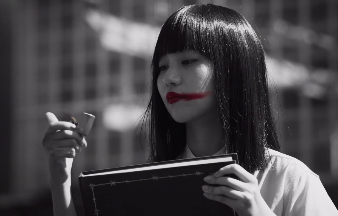 娜诺用鲜艳的口红,扎眼的绿色发带,浓艳的紫色头发一再挑战着管理者们