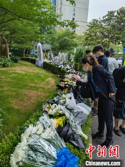 遗体告别仪式钱，民众自发送来的花圈花束已经摆满龙华殡仪馆大厅前的绿篱。陈静 摄