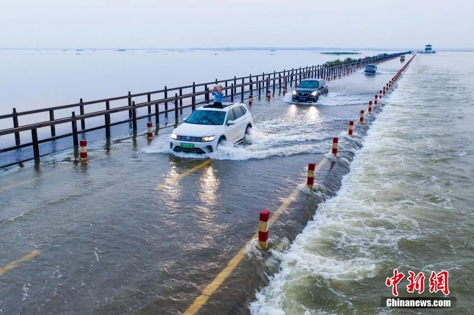 资料图：5月24日，位于江西省九江市永修县境内的永吴公路大湖池段被上涨的湖水漫过。马刚 摄