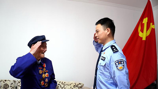 张忠杰为新党员代表沈彬戴上党徽,两人相互敬礼.吴晶晶摄