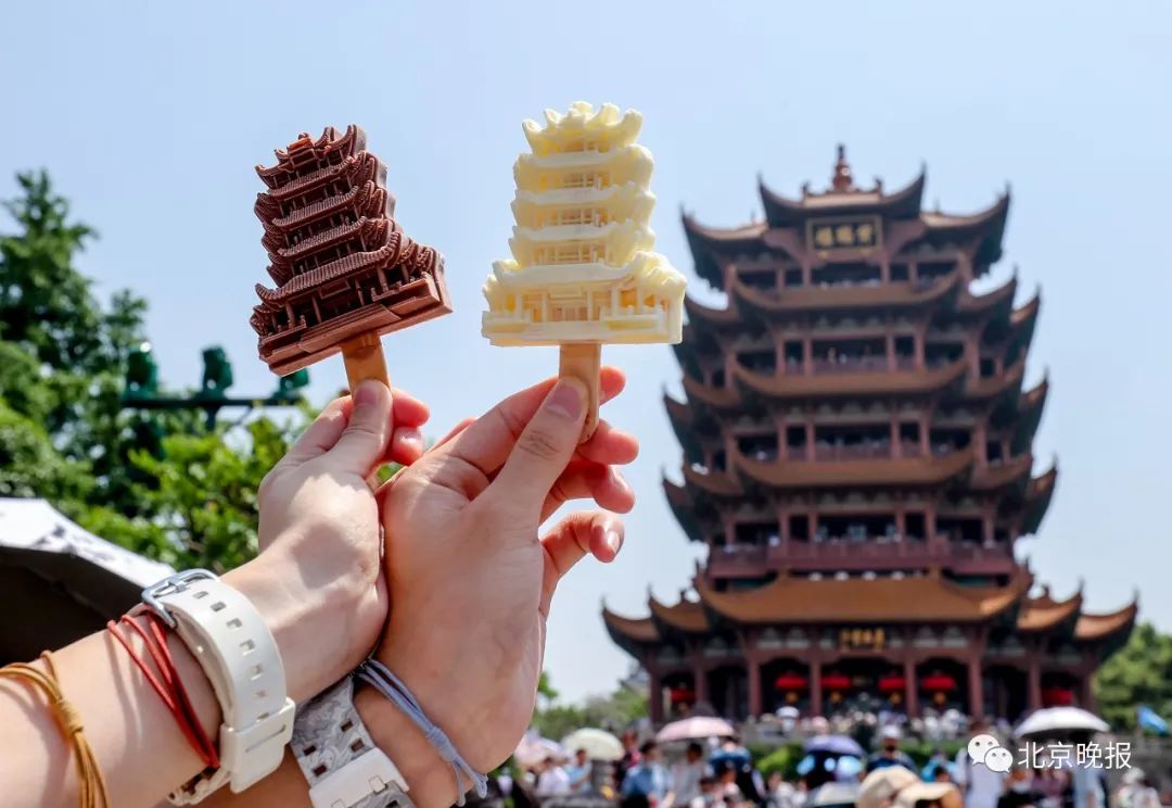 今年5月1日,游客手拿黄鹤楼网红雪糕在黄鹤楼前留影。此款雪糕自武汉黄鹤楼景区推出以来,便成为了不少游客打卡黄鹤楼时的必选品。视觉中国 供图
