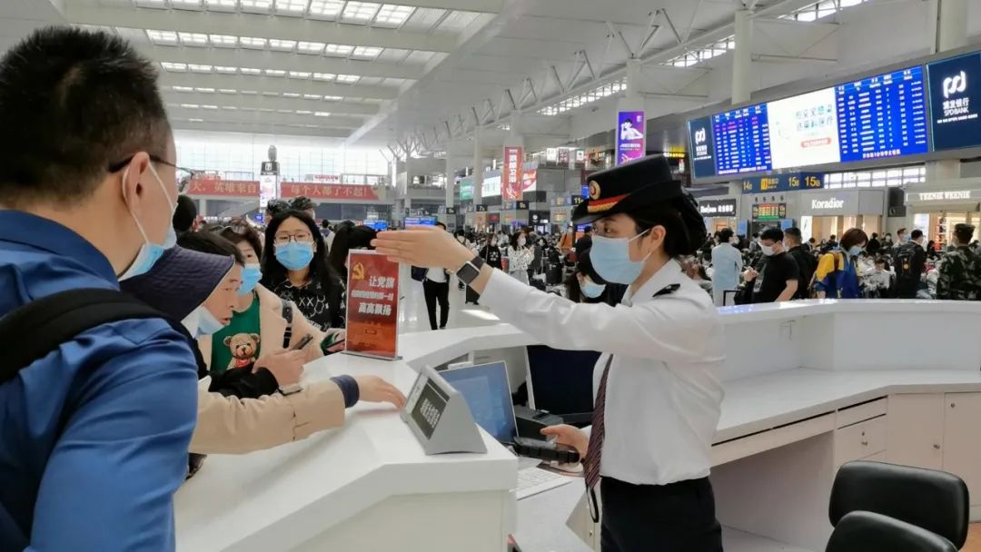 上海虹桥站工作人员为旅客提供咨询服务 王程伟 摄