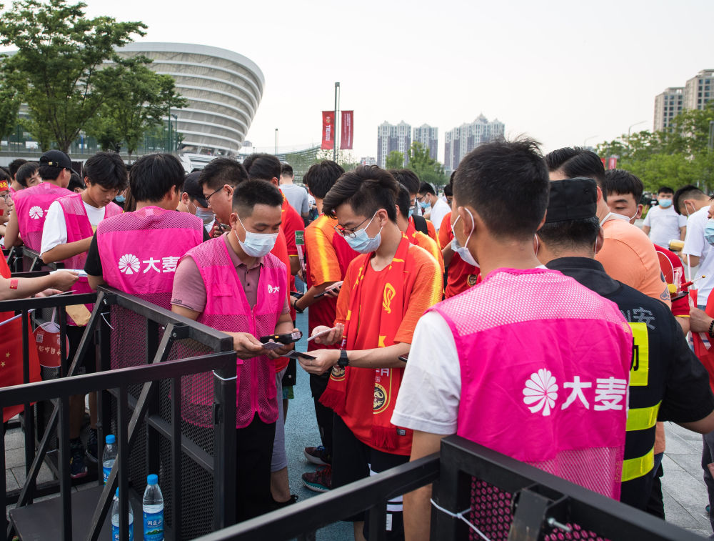 ↑球迷在比赛前排队入场。新华社记者肖艺九摄