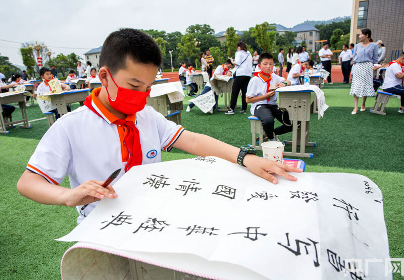 在江西省九江市都昌县湖滨学校操场,学生在进行毛笔书写比赛.