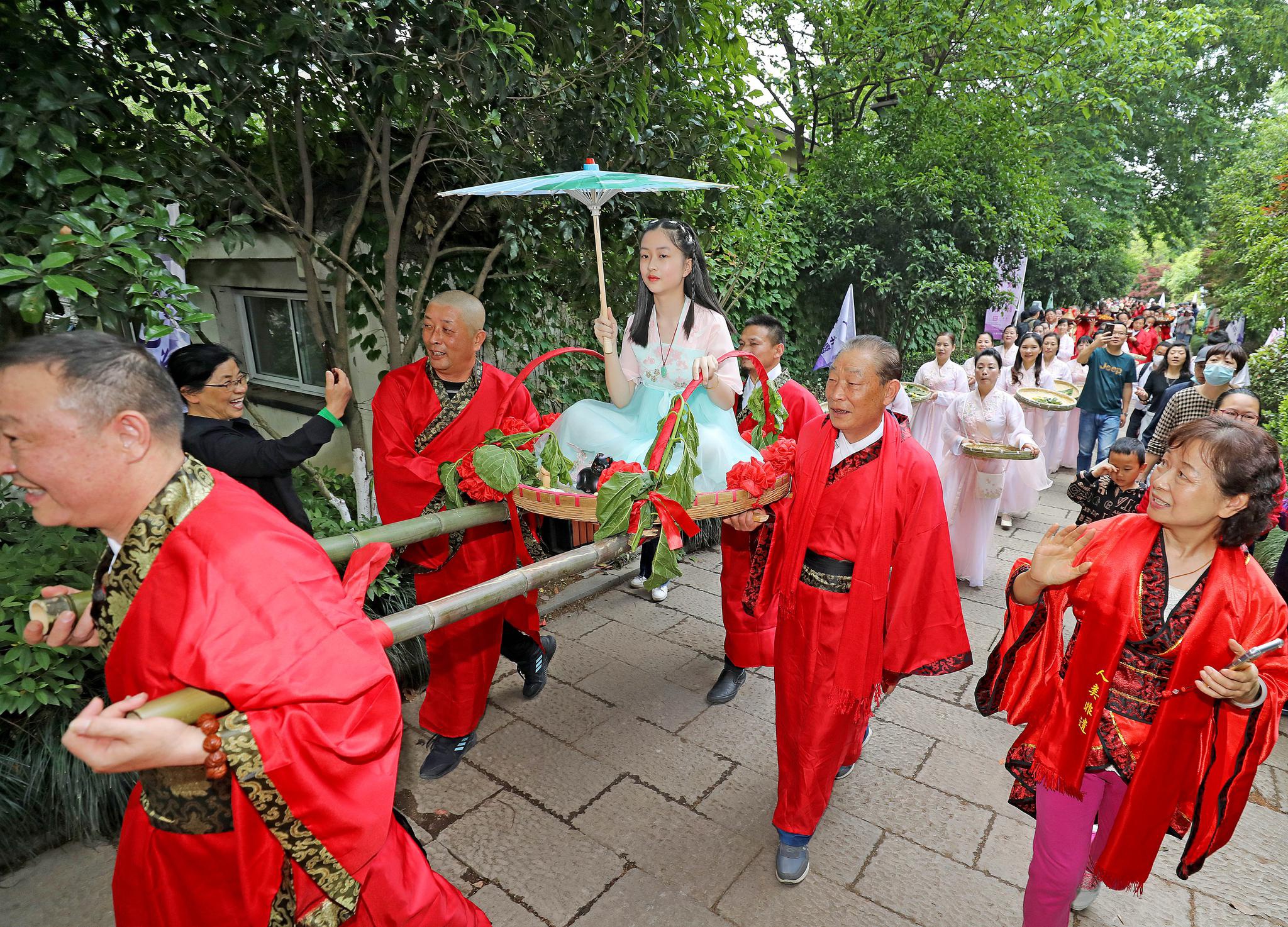 现场以"送春迎夏"古礼仪式以及大秤称人,煮蚕豆,吃乌米饭,斗蛋,画泥猫