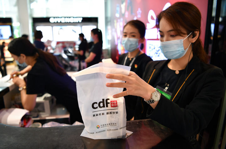 店员在海南博鳌免税店为消费者打包(4月19日摄)。 新华社记者 郭程 摄