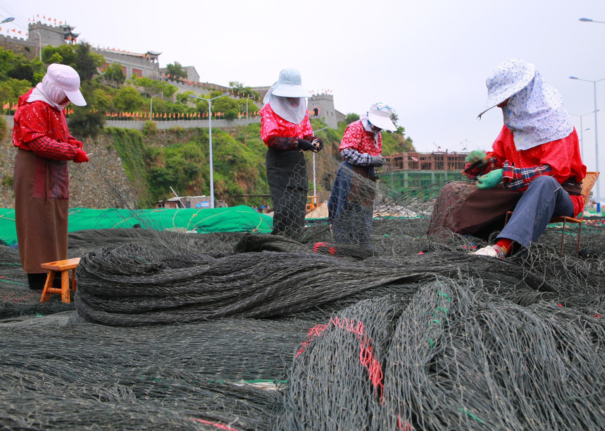 1日进入东海伏季休渔期来,玉环渔民休渔不休工,纷纷抓紧时间修补渔网