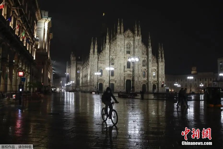 资料图：意大利米兰，男子骑车经过一座哥特式大教堂。