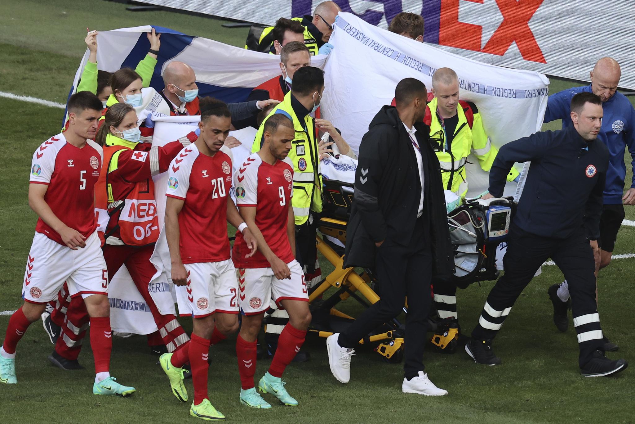 丹麦球员护送埃里克森离场。