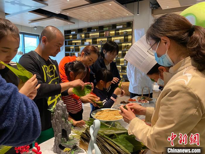 端午假期，游客在排云型旅体验包粽子 邵海钊 摄