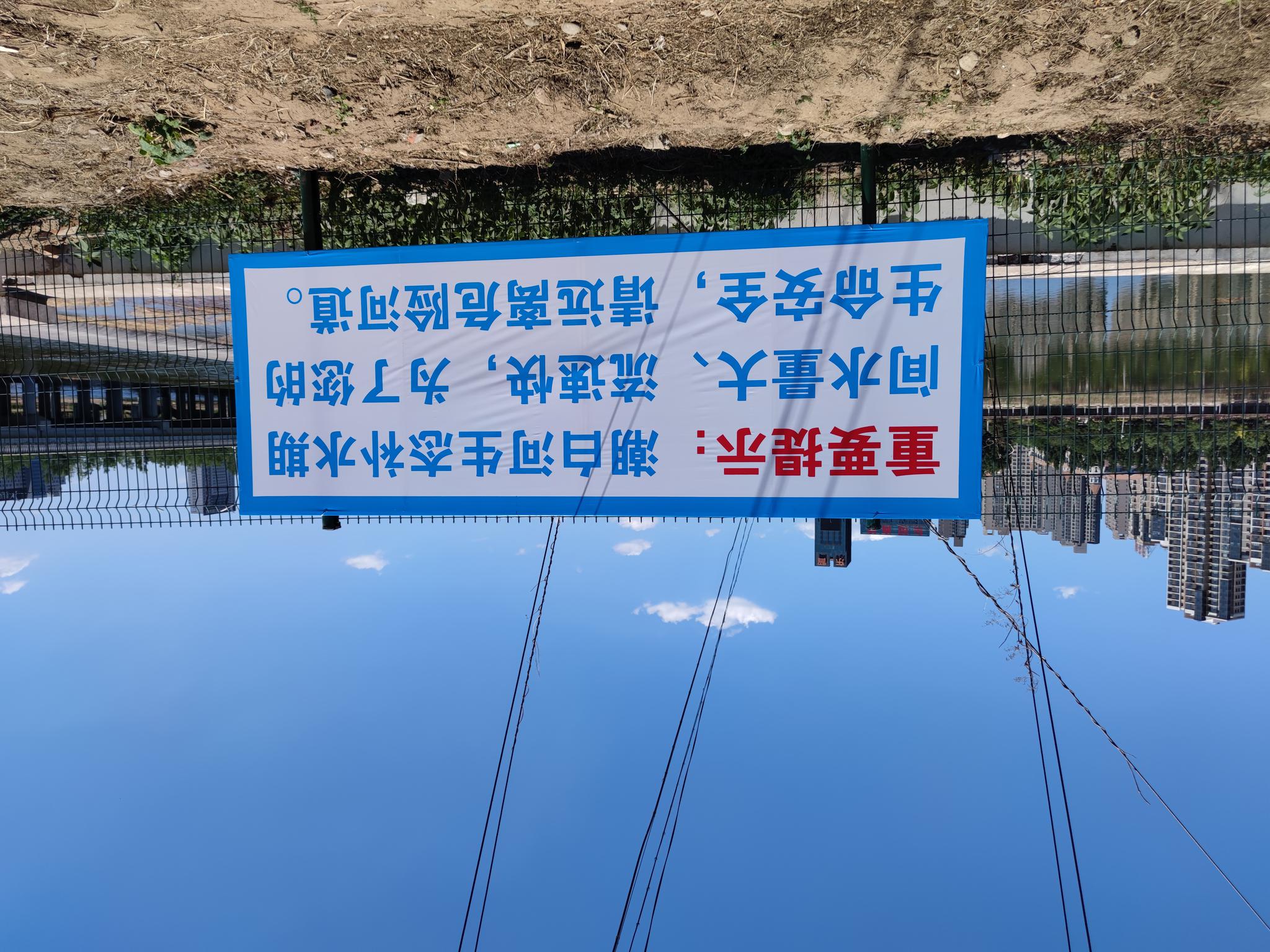 潮白河白庙橡胶坝附近的补水安全提示标语。 新京报记者 赵敏 摄