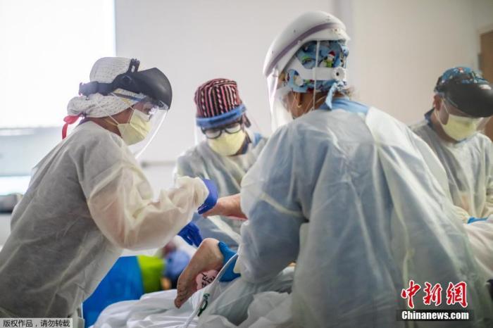 资料图:图为美国加州塔尔扎纳一家医疗中心的重症病房内医护人员正在为新冠肺炎患者进行治疗。