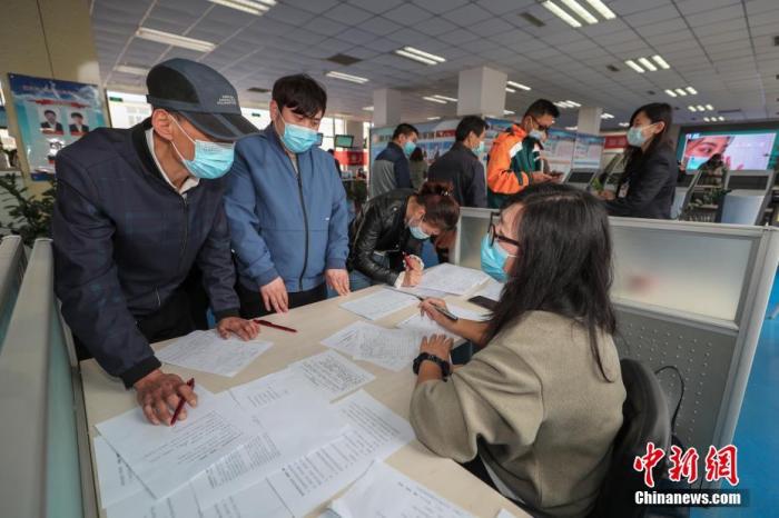 资料图：4月2日，北京市顺义区人力资源市场内，求职者（左）与用工企业交谈。 中新社记者 贾天勇 摄