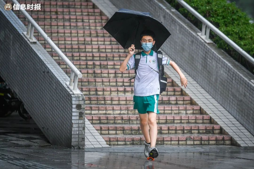 傍晚时分,广州大道南,一位撑伞的学生在雨中奔跑.