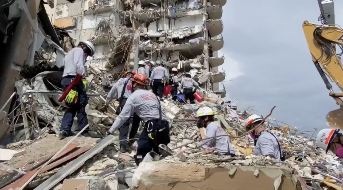 当地时间2021年6月25日，救援人员在美国佛罗里达州瑟夫赛德镇发生局部坍塌的住宅楼废墟上搜救（视频截图）。