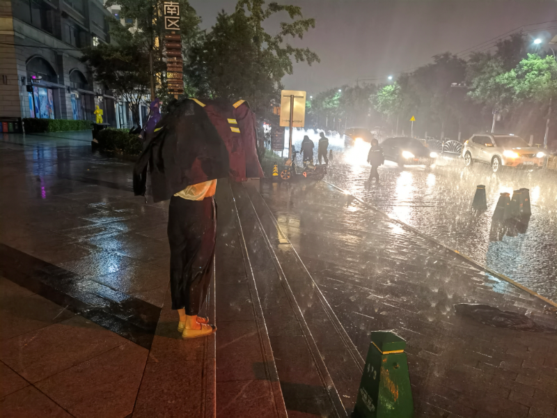 昨晚北京大雨有车遇积水,消防员背起老人孩子过马路