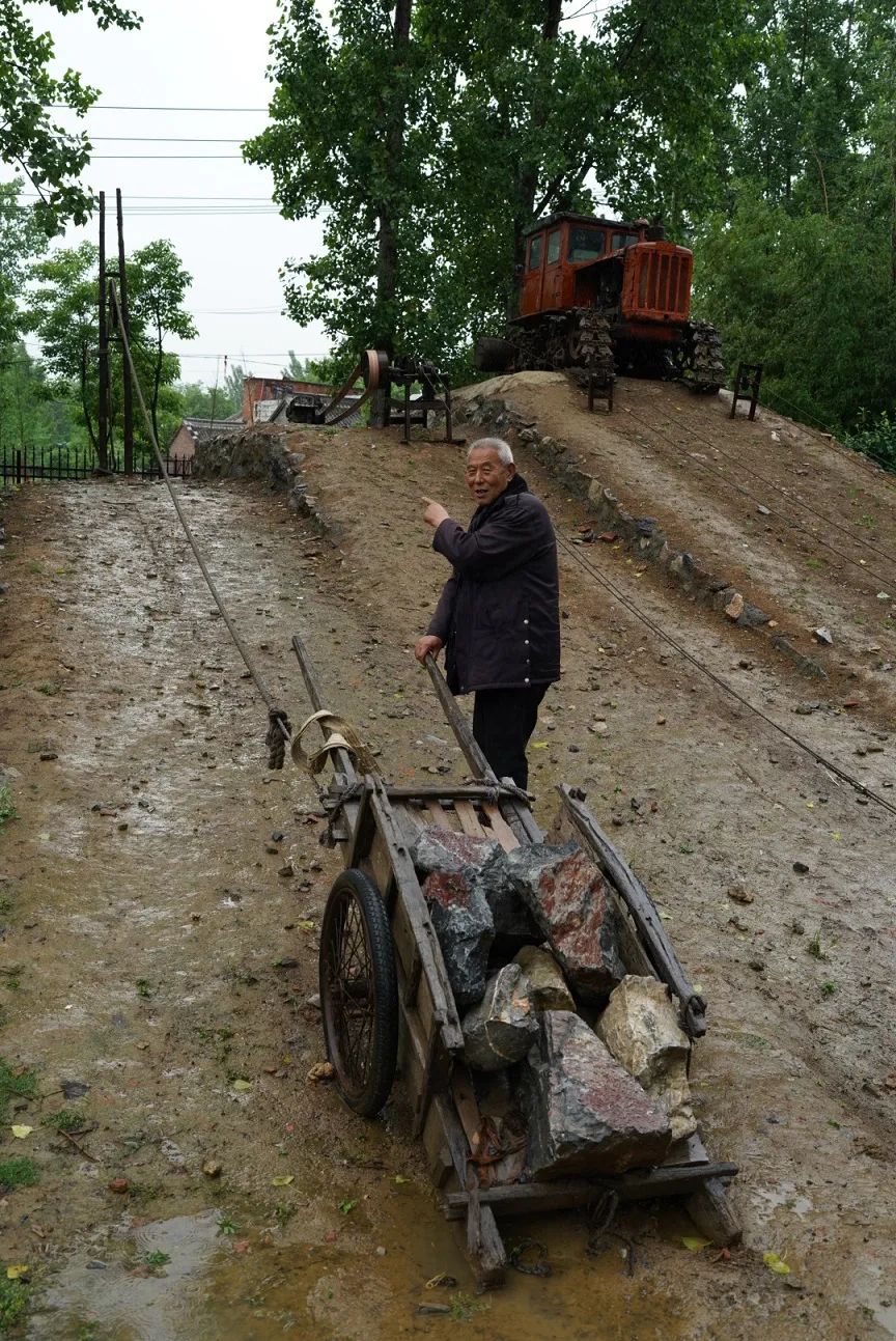 部旧址博物馆,唐金顺在爬坡器前讲述当年重车上坡与飞车下坡的场景