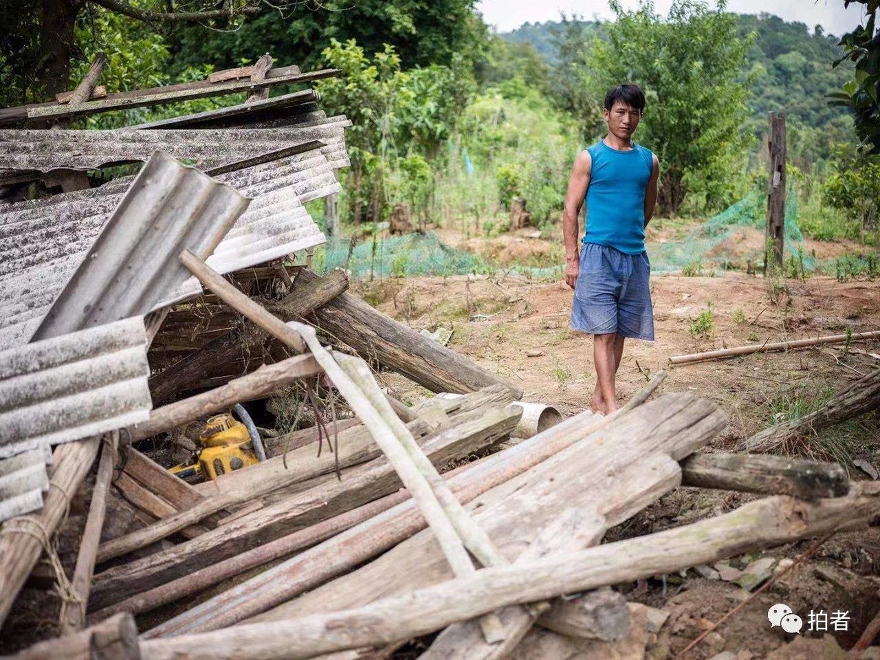 西双版纳勐海县勐阿镇，村民站在被大象破坏的房屋前。