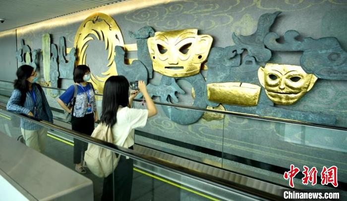 T2国际到达旅客通道墙上的“三星堆”元素吸引过往者拍照。刘忠俊 摄