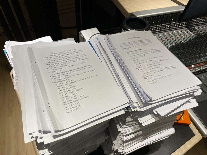 录音棚内堆着厚厚一摞志愿者们使用过的讲述稿