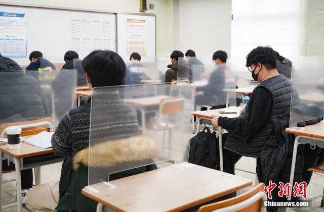 资料图:当地时间2020年12月3日,延迟近一个月的韩国高考举行。图为在首尔某考点内,考桌上设有隔板。 中新社发 首尔市教育厅 供图