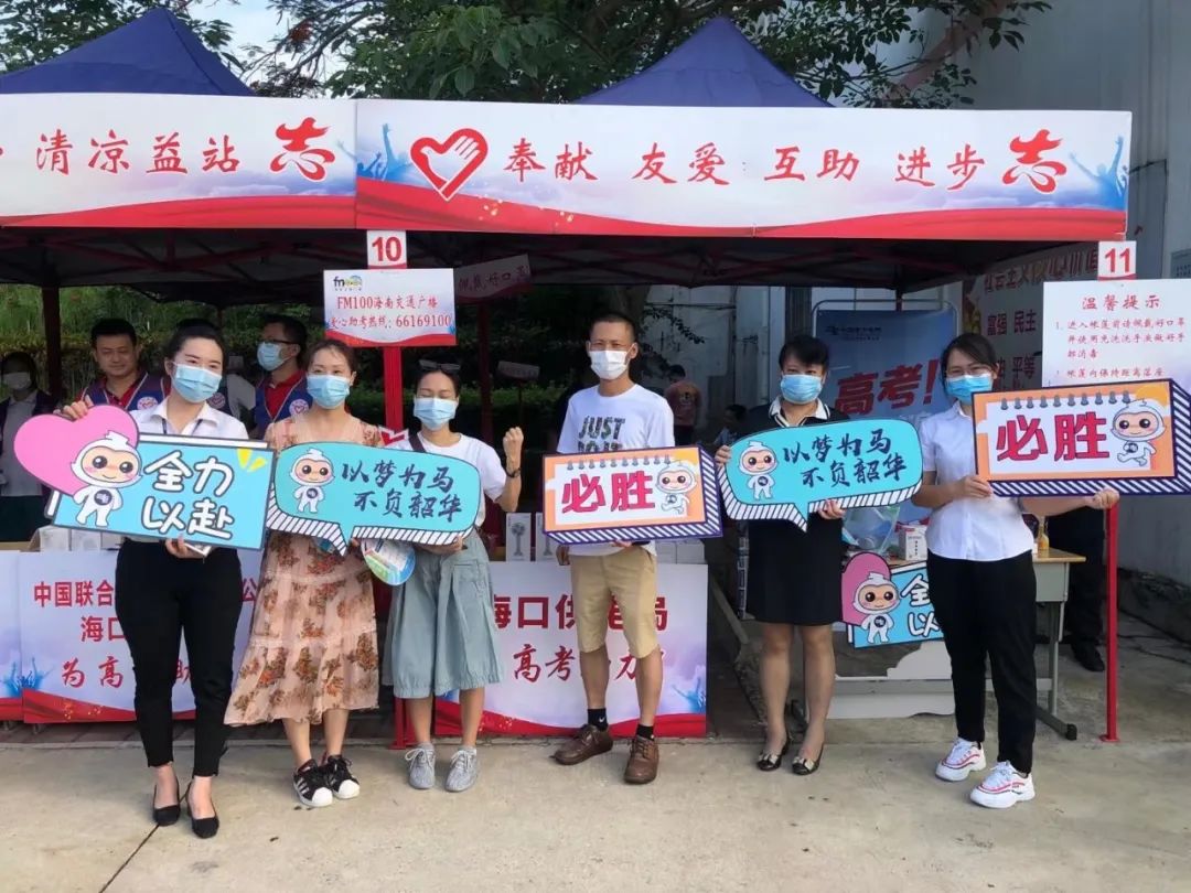 为考生们加油助威志愿服务人员手举可爱彩色标语牌在海南华侨中学考点