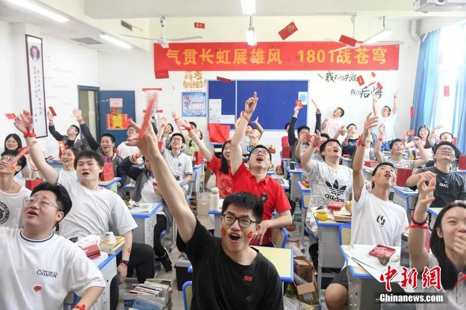 资料图：6月6日，湖南长沙同升湖实验学校教师与考生抛起红包迎接高考。杨华峰 摄