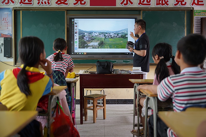 支教老师殷锡铭向学生展示无人机拍摄的照片。澎湃新闻记者胡弘彪图