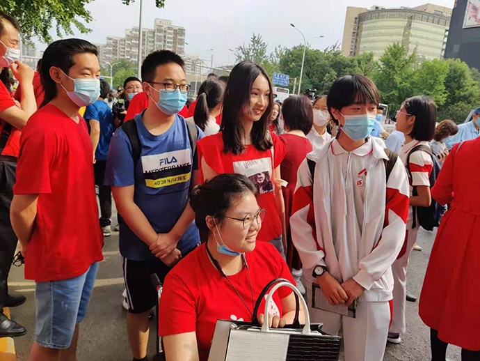 坐在轮椅上的卞亦博（前排中）及其他送考的同学与今年高考的同学合影留念。本文图片均为澎湃新闻记者 程婷 图