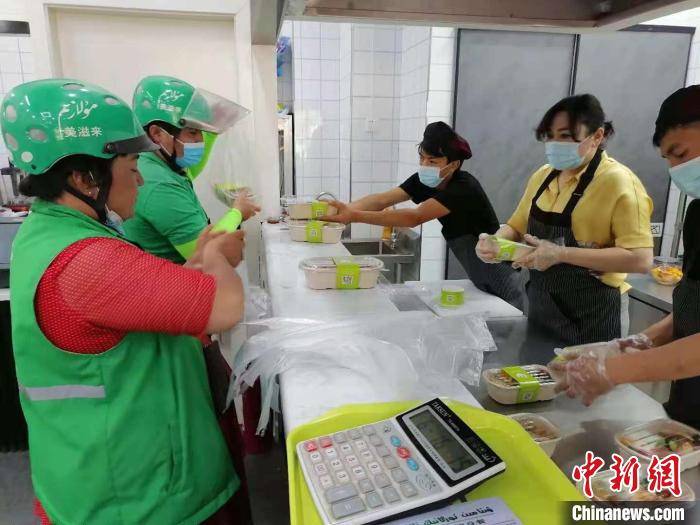 每天12时许,当地外卖小哥到店取餐. 朱景朝 摄